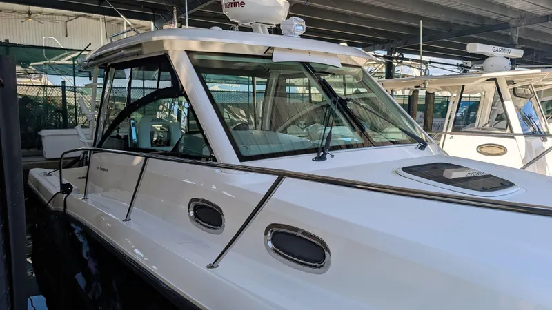 Slide: The Image of 2014 Boston Whaler 315 Conquest boat docked under shelter. - 12