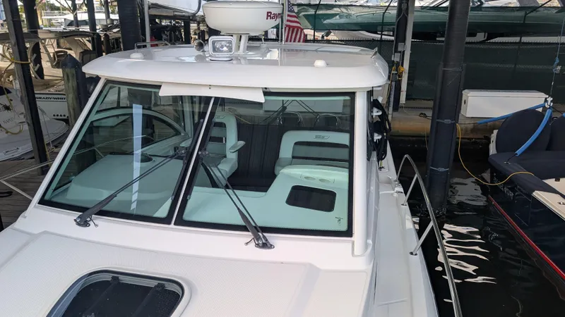 Slide: The Image of 2014 Boston Whaler 315 Conquest boat docked, featuring a sleek cabin and windshield. - 15