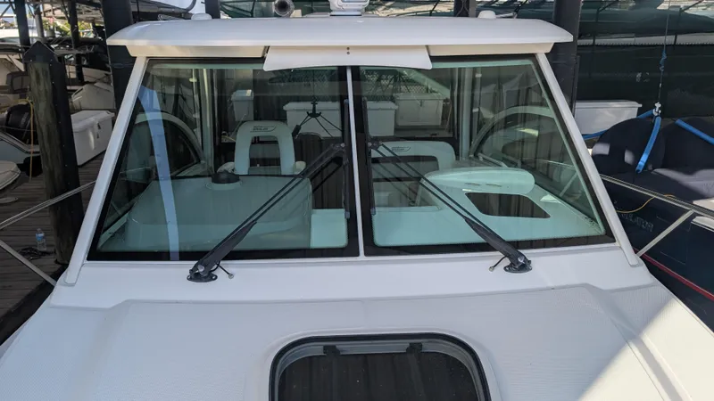 Slide: The Image of 2014 Boston Whaler 315 Conquest boat with windshield wipers, docked in a marina. - 17