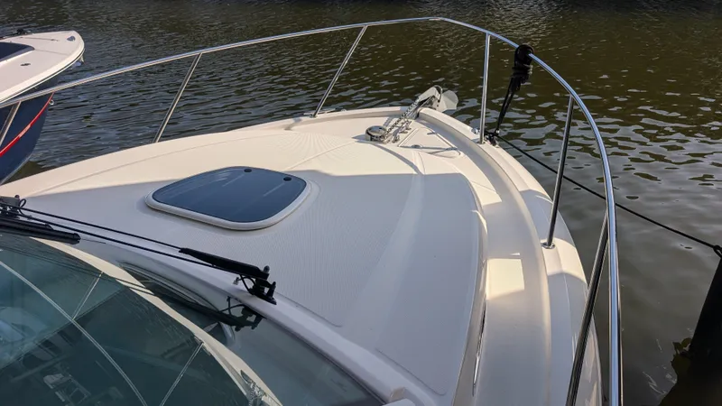 Slide: The Image of 2014 Boston Whaler 315 Conquest boat deck with railing, docked on calm water. - 18