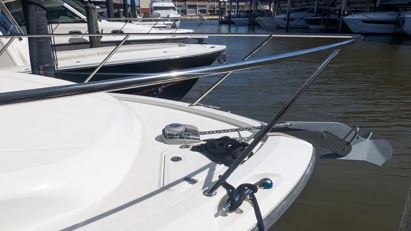 Slide: The Image of 2014 Boston Whaler 315 Conquest boat docked, featuring anchor and railing. - 19