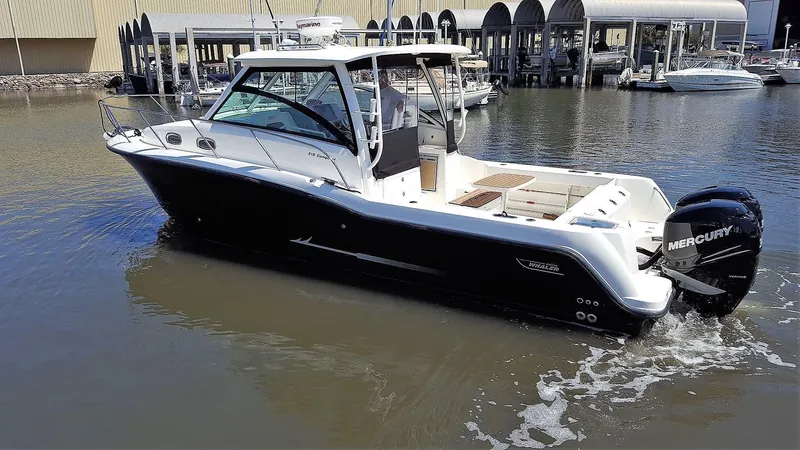 Slide: The Image of 2014 Boston Whaler 315 Conquest boat with Mercury engines on calm water. - 2