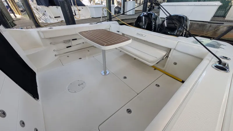 Slide: The Image of 2014 Boston Whaler 315 Conquest boat interior with seating and table. - 23