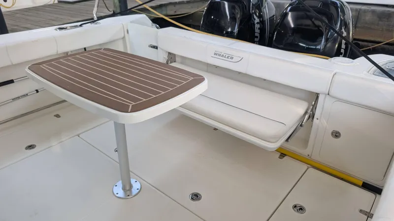 Slide: The Image of 2014 Boston Whaler 315 Conquest boat interior with table and seating area. - 24