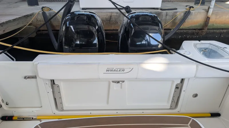 Slide: The Image of 2014 Boston Whaler 315 Conquest boat with dual outboard engines at dock. - 25