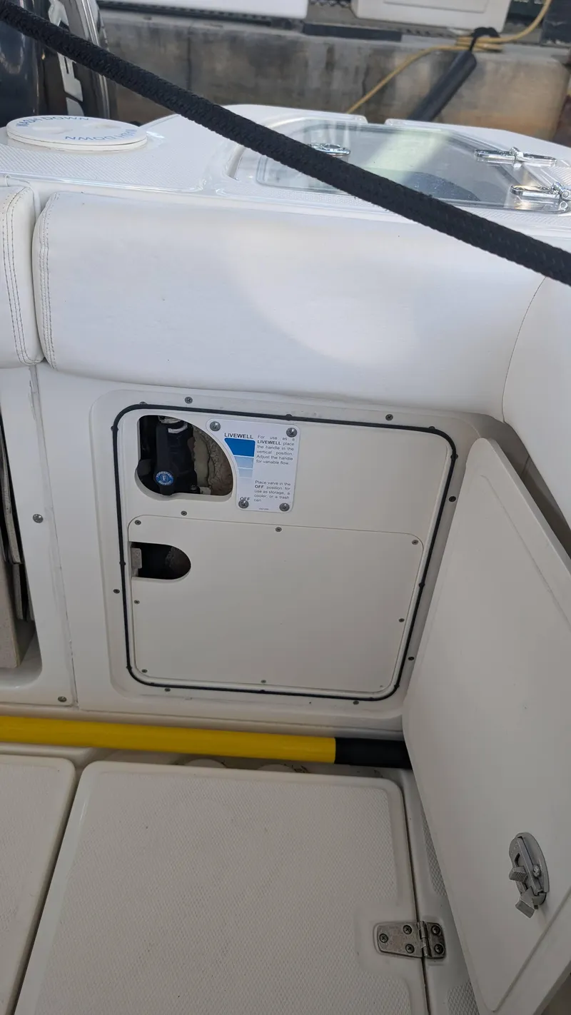 Slide: The Image of 2014 Boston Whaler 315 Conquest boat interior, showing storage compartment and seating area. - 26
