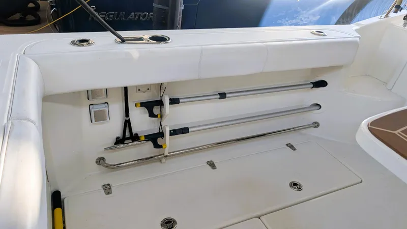 Slide: The Image of 2014 Boston Whaler 315 Conquest boat interior with rod holders and storage compartment. - 29