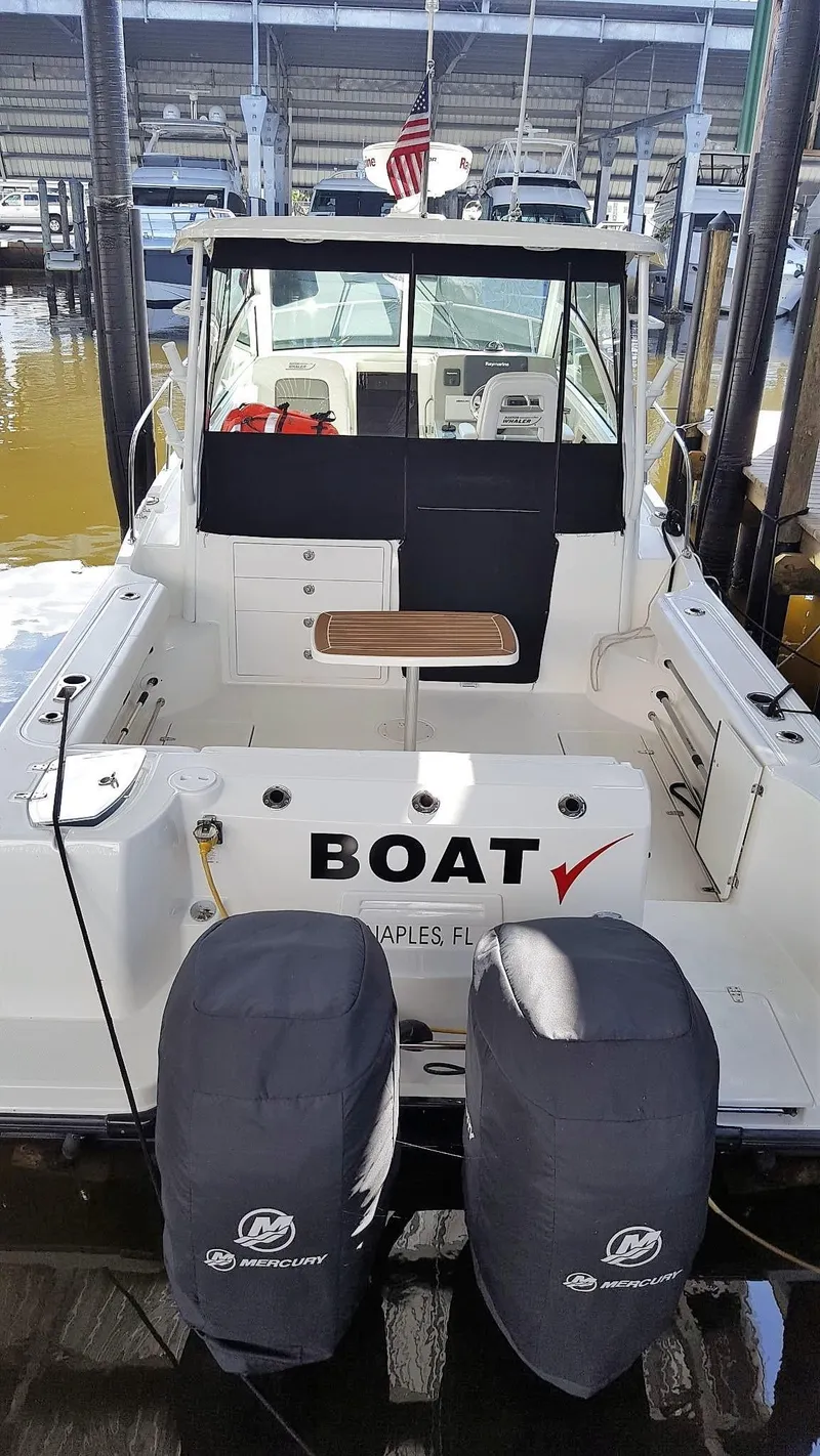 Slide: The Image of 2014 Boston Whaler 315 Conquest docked, featuring dual Mercury engines, in Naples, Florida. - 3