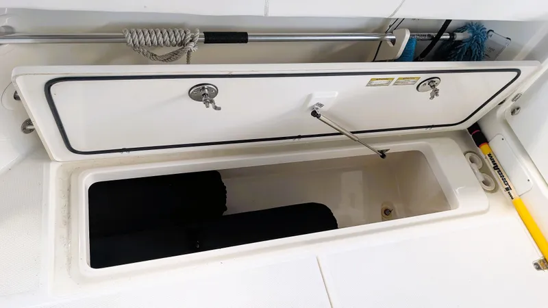Slide: The Image of Open storage compartment on 2014 Boston Whaler 315 Conquest boat, featuring secure latches and organized space. - 32
