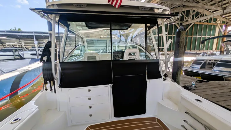 Slide: The Image of 2014 Boston Whaler 315 Conquest boat interior with covered cockpit in marina setting. - 38