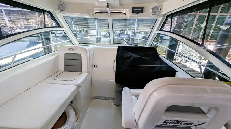 Slide: The Image of 2014 Boston Whaler 315 Conquest interior with seating and helm, docked in marina. - 39