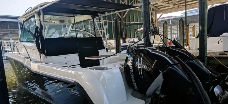 Slide: The Image of 2014 Boston Whaler 315 Conquest boat docked with Mercury engines in a marina. - 4