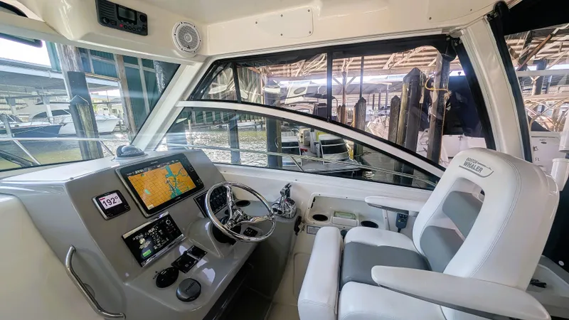 Slide: The Image of 2014 Boston Whaler 315 Conquest helm with navigation screens and comfortable seating. - 42