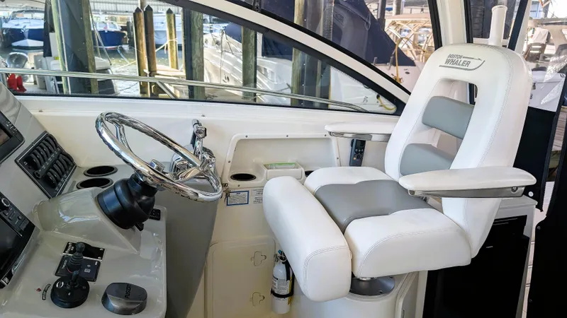 Slide: The Image of 2014 Boston Whaler 315 Conquest helm with steering wheel and captain's chair. - 45