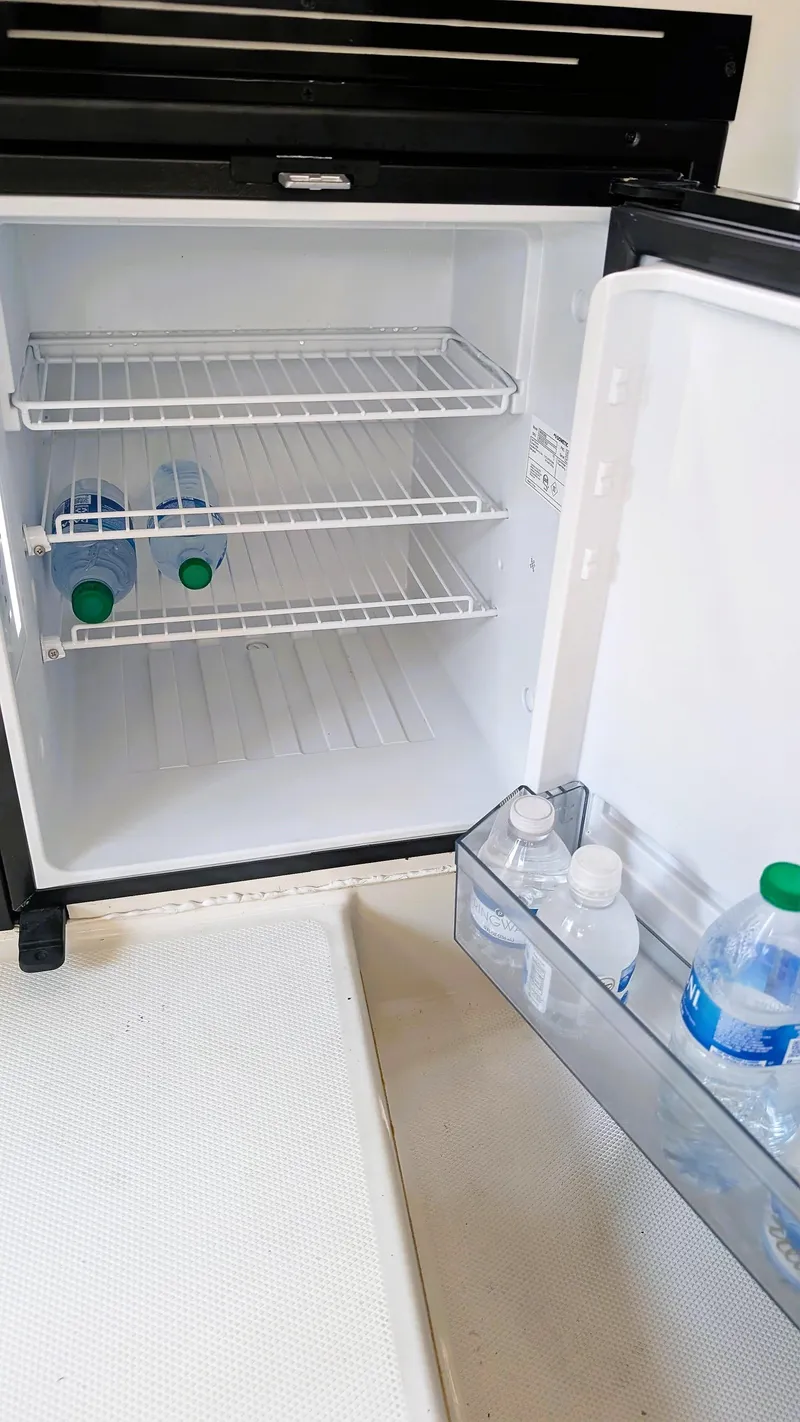 Slide: The Image of Mini fridge with water bottles inside a 2014 Boston Whaler 315 Conquest boat. - 47