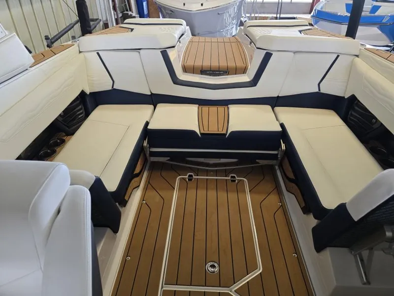 Slide: The Image of 2025 Nautique Super Air Nautique G23 interior with luxurious seating and teak flooring. - 12