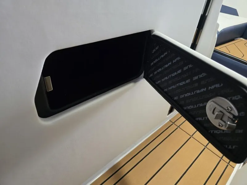 Slide: The Image of 2025 Nautique Super Air Nautique G23 storage compartment with open hatch and sleek interior design. - 17