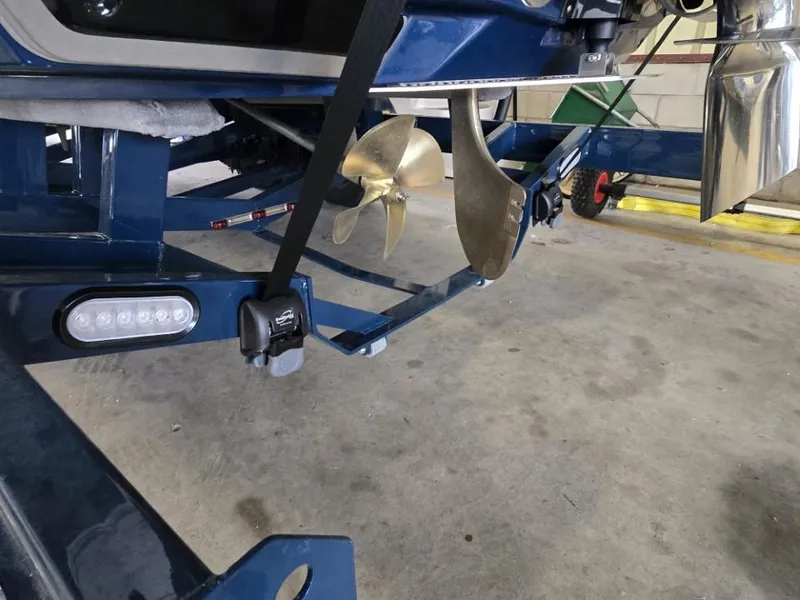 Slide: The Image of 2025 Nautique Super Air Nautique G23 boat propeller and trailer detail in a garage. - 21