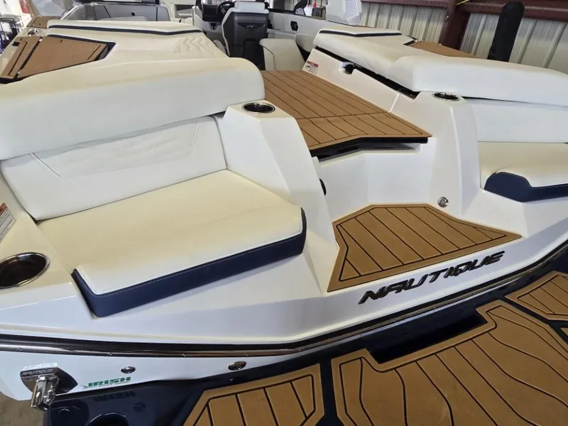 Slide: The Image of 2025 Nautique Super Air Nautique G23 boat interior with white seating and teak flooring. - 23