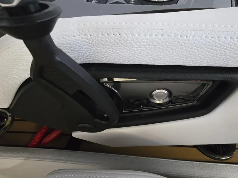 Slide: The Image of Interior detail of 2025 Nautique Super Air Nautique G23 boat, featuring sleek controls and white upholstery. - 26