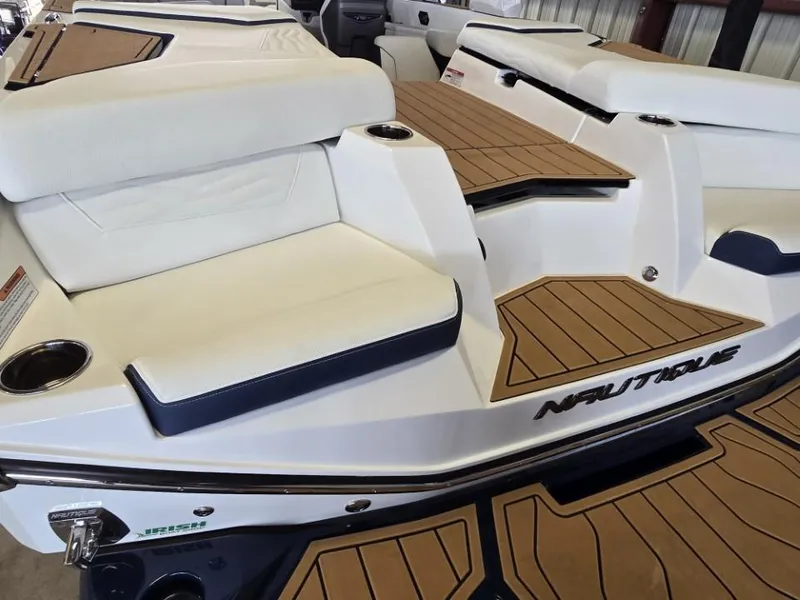 Slide: The Image of 2025 Nautique Super Air Nautique G23 boat interior with white seating and teak flooring. - 27