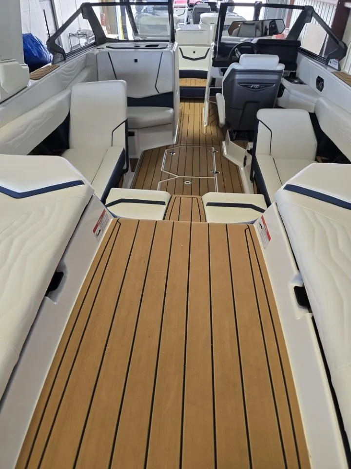 Slide: The Image of 2025 Nautique Super Air Nautique G23 interior with sleek seating and wooden flooring. - 29