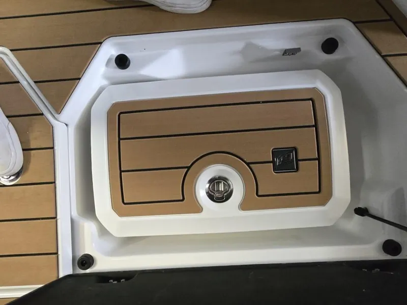 Slide: The Image of 2025 Nautique Super Air Nautique G23 deck with storage compartment, featuring teak-style finish. - 41