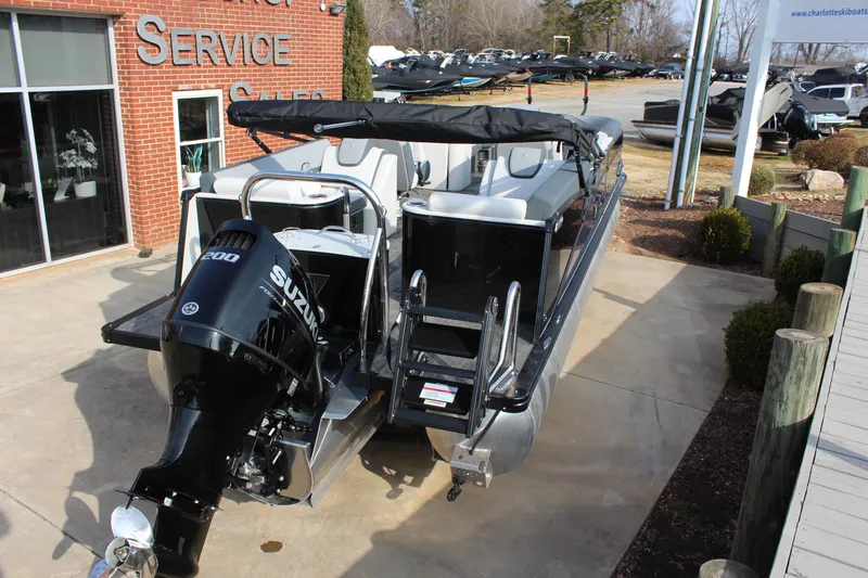 Slide: The Image of 2025 Tahoe Pontoon Cascade QLS with Suzuki 200 engine, parked outside service center. - 4