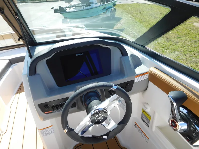 Slide: The Image of 2025 Chaparral 23 SSi boat dashboard with steering wheel and control panel. - 2