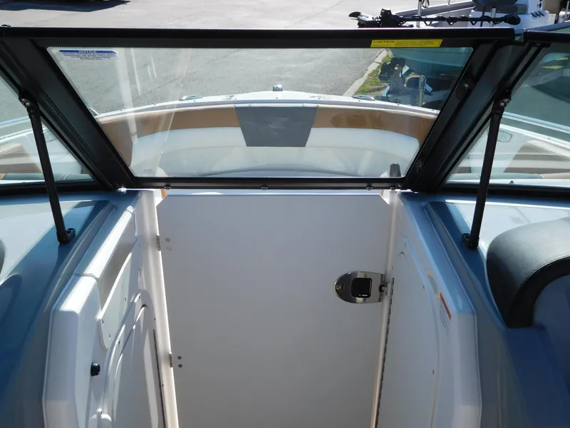 Slide: The Image of 2025 Chaparral 23 SSi boat interior with open cabin door and windshield view. - 7