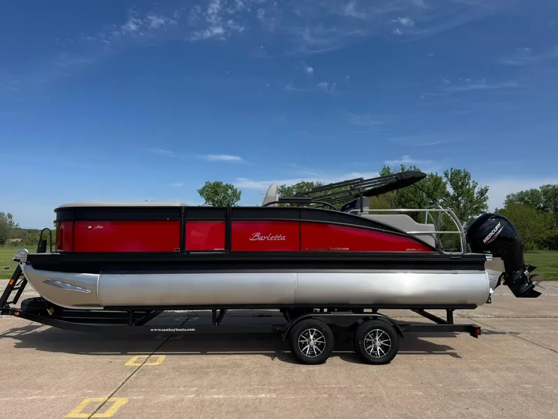 Slide: The Image of 2025 Barletta ARIA 22UC pontoon boat on trailer, red and silver design. - 2