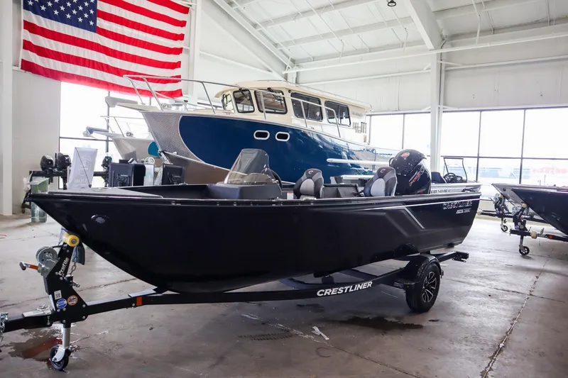Slide: The Image of 2025 Crestliner 1750 Hawk SC boat displayed indoors with American flag backdrop. - 2