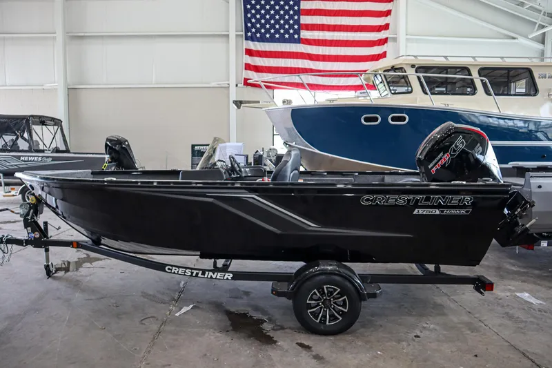 Slide: The Image of 2025 Crestliner 1750 Hawk SC boat in showroom with American flag backdrop. - 4