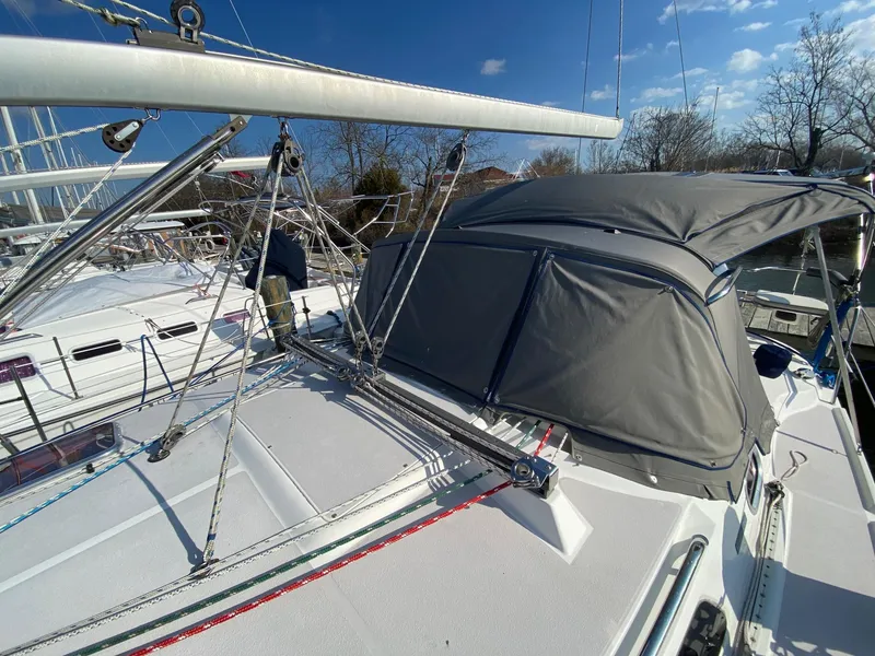Slide: The Image of 2004 Catalina 350 sailboat with gray canopy, docked under clear blue sky. - 19