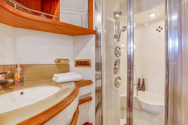 Slide: The Image of Luxurious bathroom in a 2005 Azimut 55E yacht with modern fixtures and wooden accents. - 27