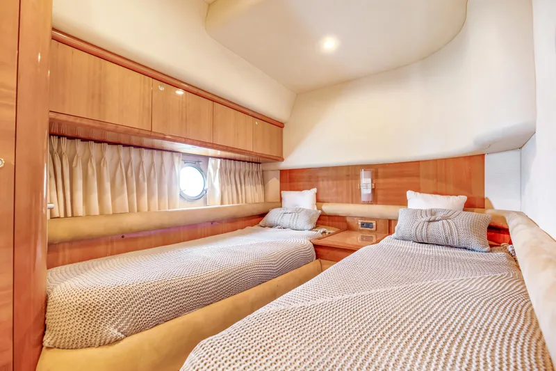 Slide: The Image of Luxurious twin cabin in 2005 Azimut 55E yacht, featuring elegant wood finishes and cozy bedding. - 28