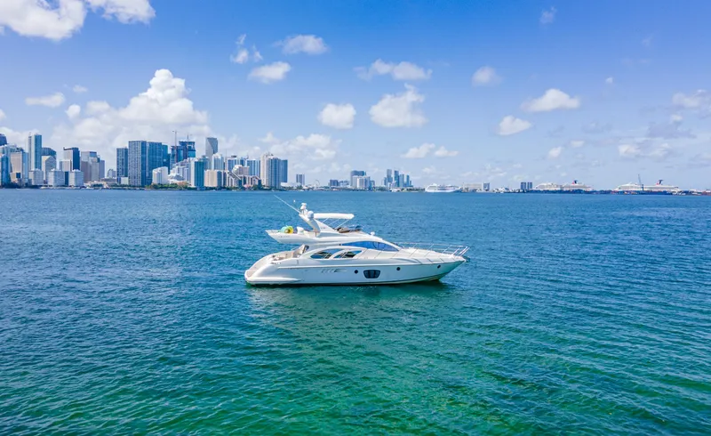 Slide: The Image of Azimut 55E yacht from 2005 cruising near a city skyline on a sunny day. - 3