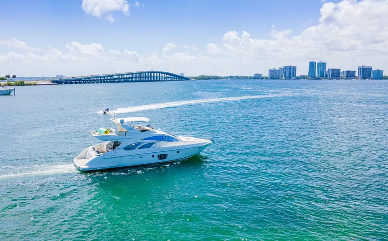 Slide: The Image of Azimut 55E yacht cruising on blue waters near a city skyline, 2005 model. - 8