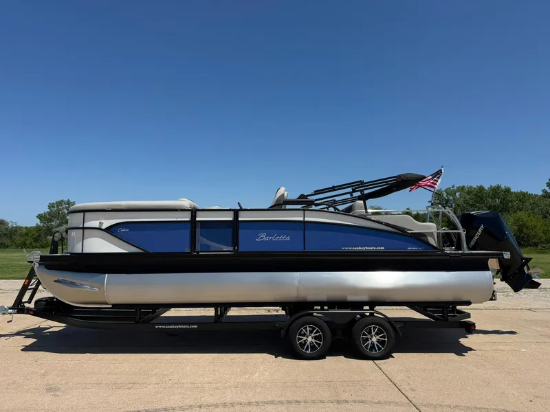 Slide: The Image of 2025 Barletta Cabrio 22UC pontoon boat on trailer, clear sky background. - 3