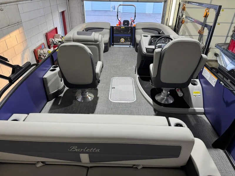 Slide: The Image of 2025 Barletta Cabrio 22UC boat interior with plush seating and modern dashboard. - 38