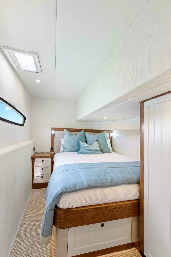 Slide: The Image of Luxurious bedroom interior on 2021 Valder Yachts Powercat, featuring cozy bedding and elegant wood accents. - 21