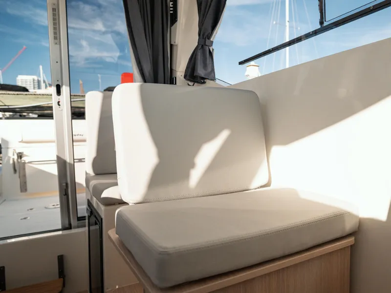 Slide: The Image of 2024 Bayliner Trophy T25PH interior seating with sunlight and modern design. - 11