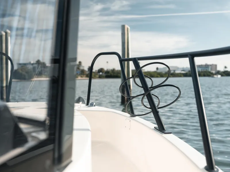 Slide: The Image of 2024 Bayliner Trophy T25PH boat on calm water near a dock. - 13