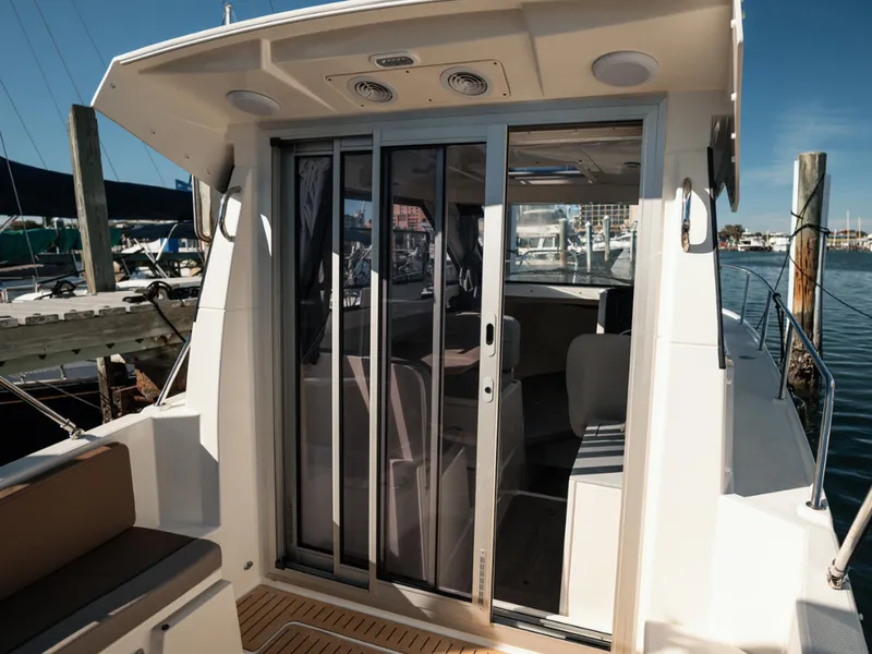 Slide: The Image of 2024 Bayliner Trophy T25PH boat with sliding glass doors at a marina. - 31