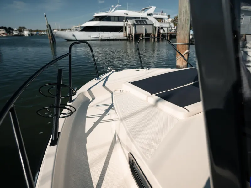 Slide: The Image of 2024 Bayliner Trophy T25PH boat docked in marina, with luxury yacht in background. - 32