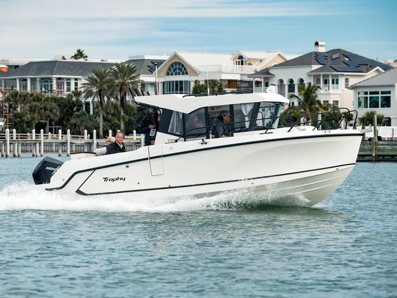 Slide: The Image of 2024 Bayliner Trophy T25PH boat cruising near waterfront homes. - 37