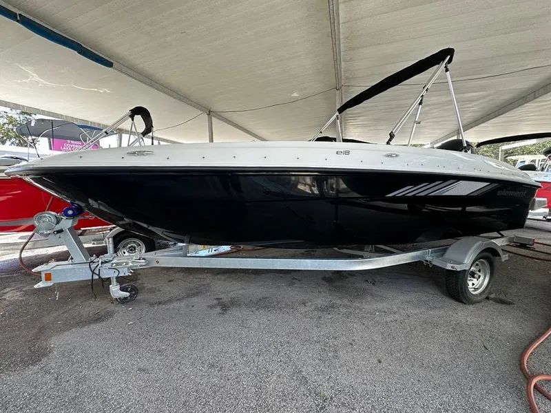 The Image of 2025 Bayliner E18 boat on trailer under canopy, side view. - 0