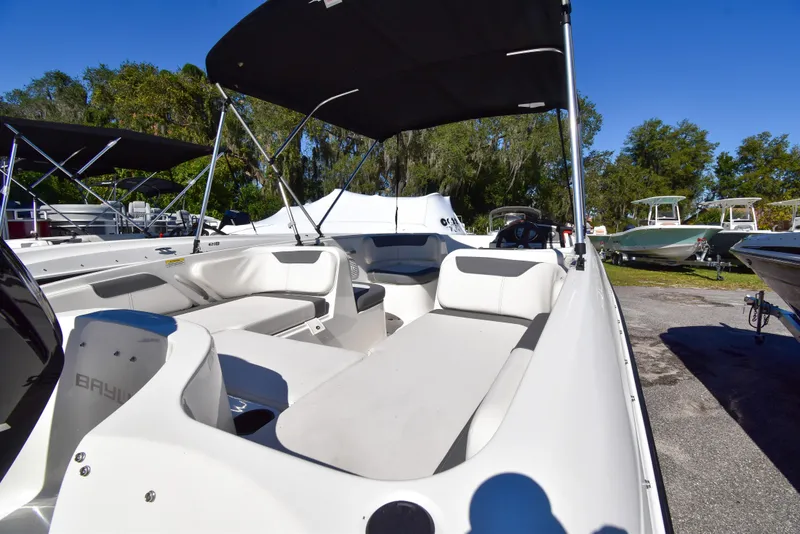 Slide: The Image of 2025 Bayliner E18 boat with spacious seating and canopy, displayed outdoors. - 1