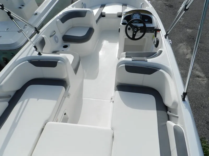 Slide: The Image of 2025 Bayliner E18 boat interior with spacious seating and modern steering console. - 2