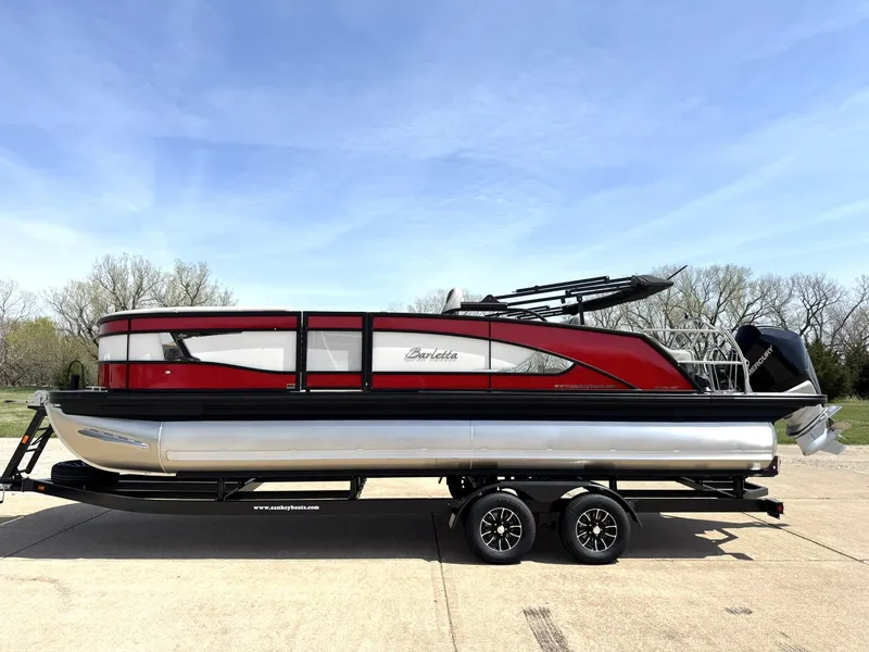 Slide: The Image of 2025 Barletta Lusso 23UC pontoon boat with red and silver design on a trailer. - 2